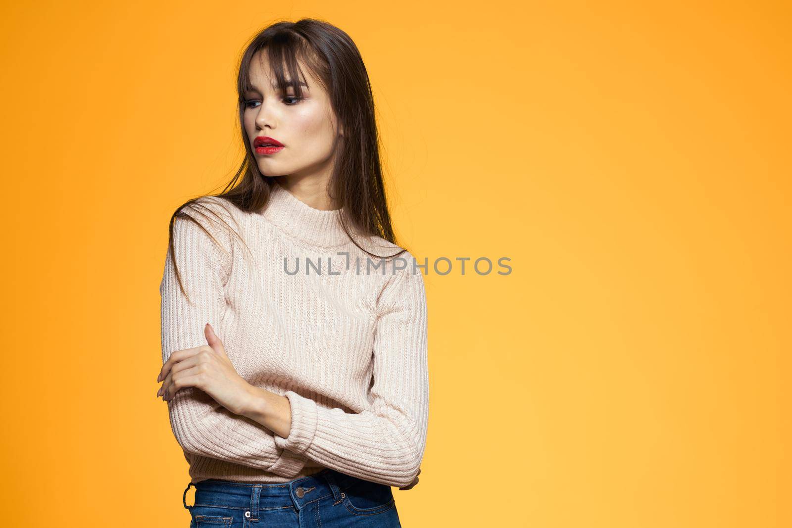 Cute brunette red lips fashionable clothes studio yellow background. High quality photo