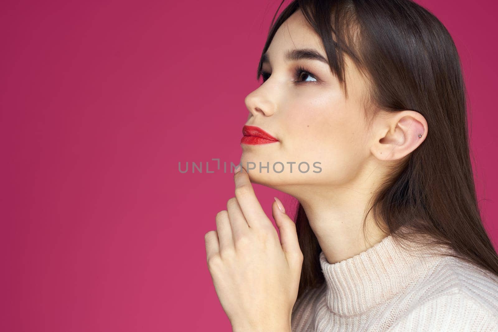 Woman with red lips bright makeup white blouse long hair pink background. High quality photo