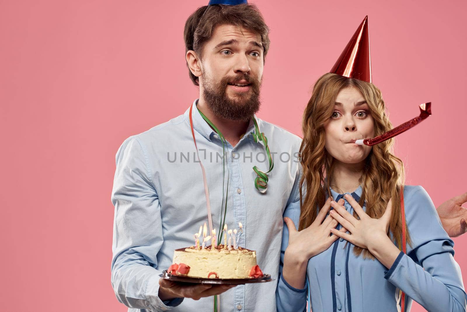 Party man and woman with cake on pink background corporate birthday. High quality photo