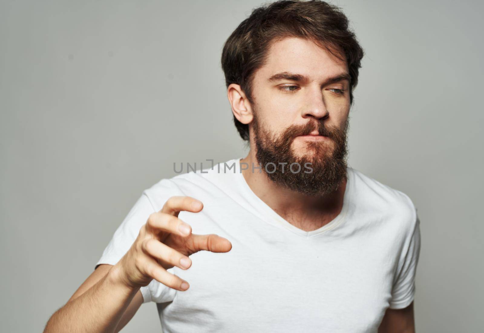 emotional man gesturing with his hands on a light background aggression scream. High quality photo