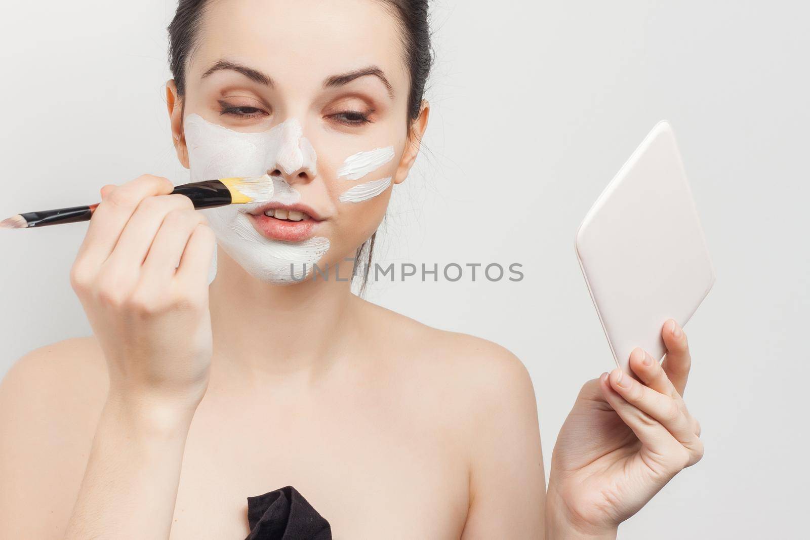 brunette applying makeup skin care cosmetics cropped view. High quality photo