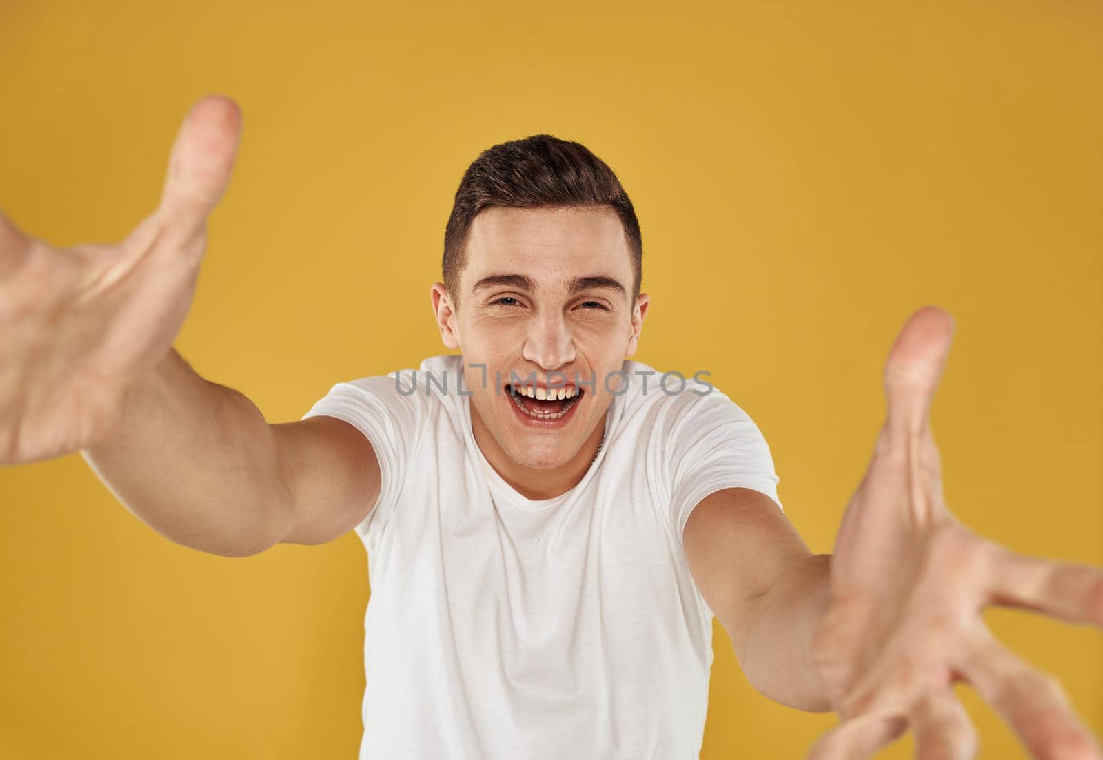 Happy guy on a yellow background gestures with his hands portrait model cropped view. High quality photo