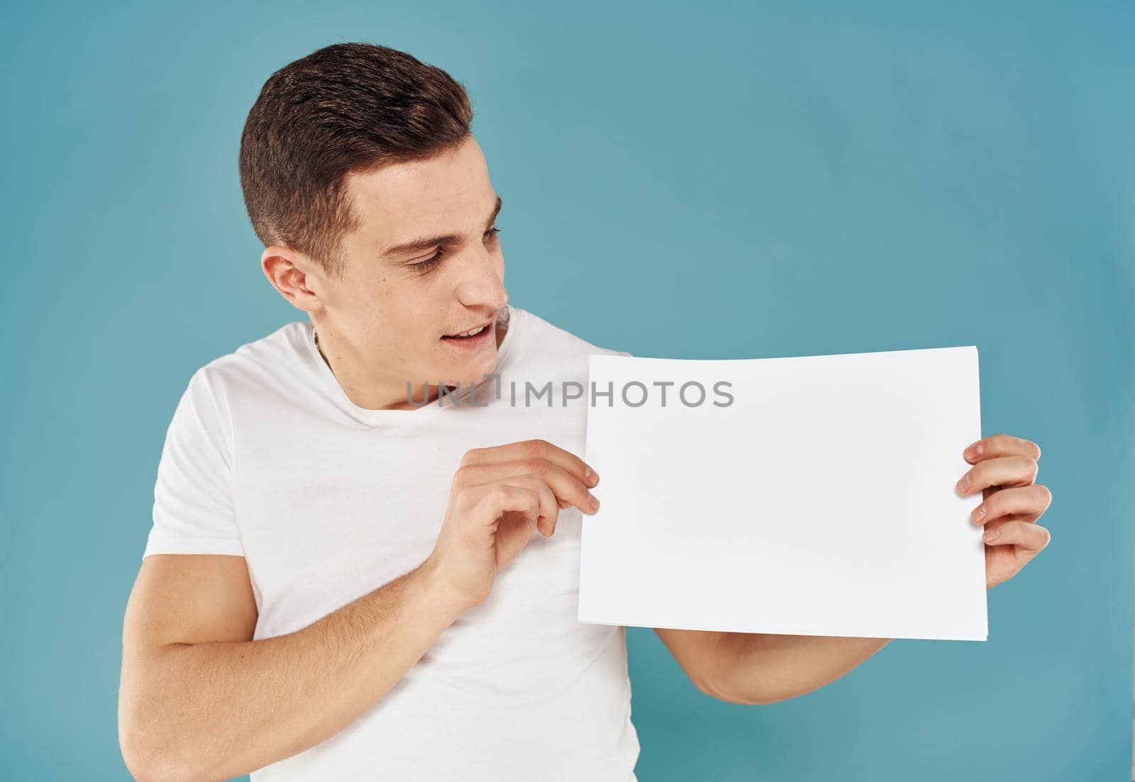 Guy with a white sheet of paper blue background advertising mocap poster. High quality photo