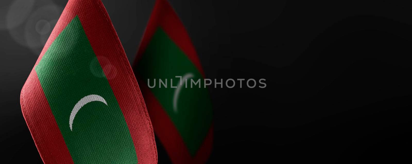 Small national flags of the Maldives on a dark background.