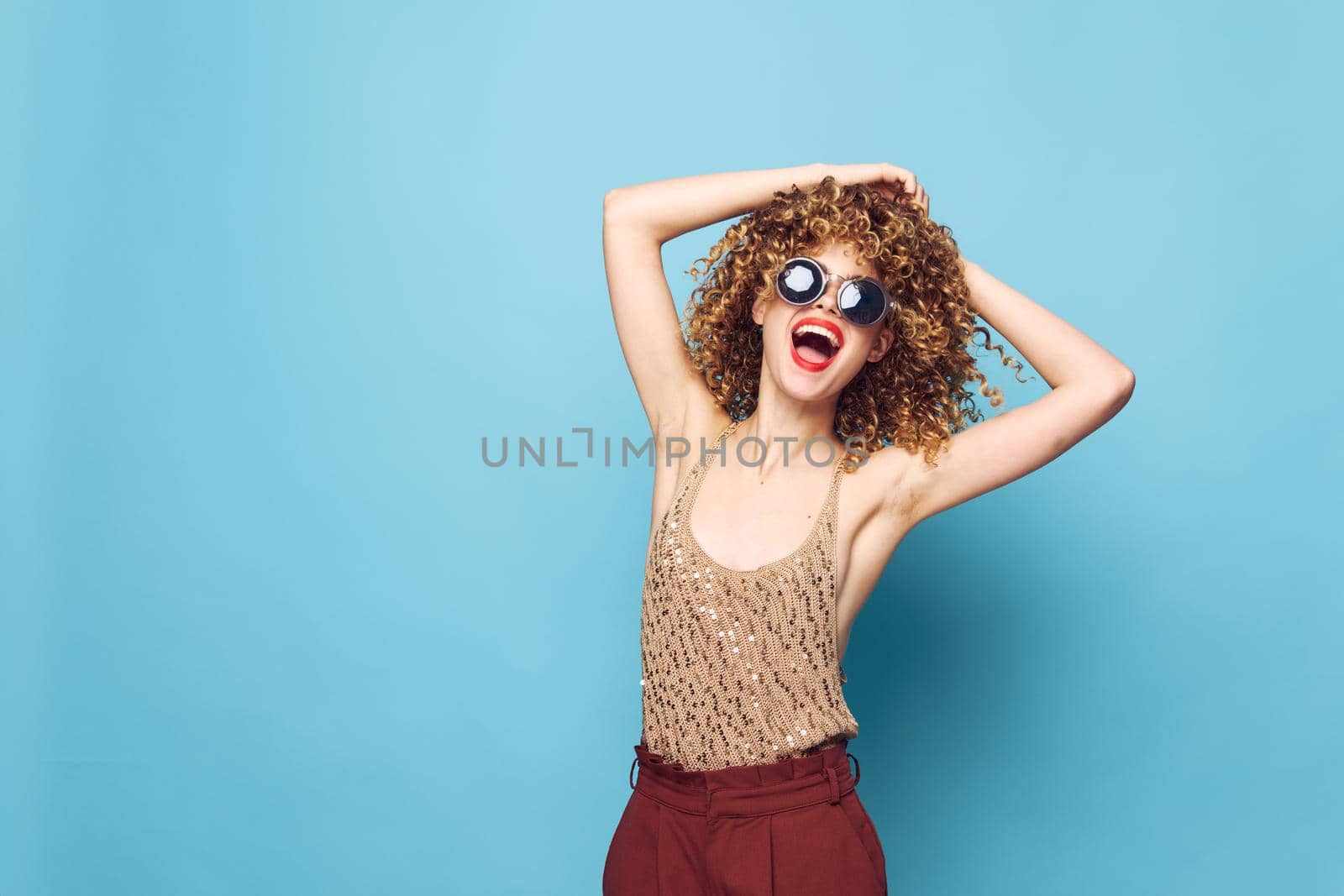 Attractive woman curly hair fun Studio fashion attractive look brown pants isolated background