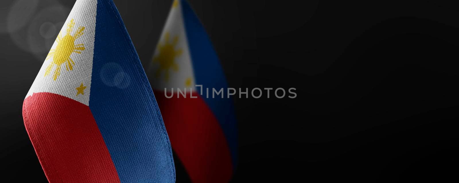 Small national flags of the Philippines on a dark background.