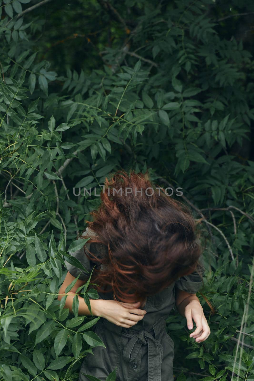 Portrait of a woman Leaned forward and the green leaves of the Bushes nature travel cropped view