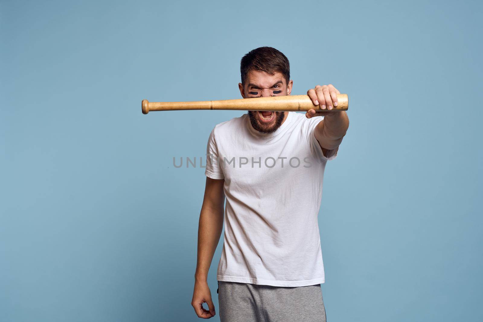 Man in white t-shirt baseball bat sport blue background. High quality photo