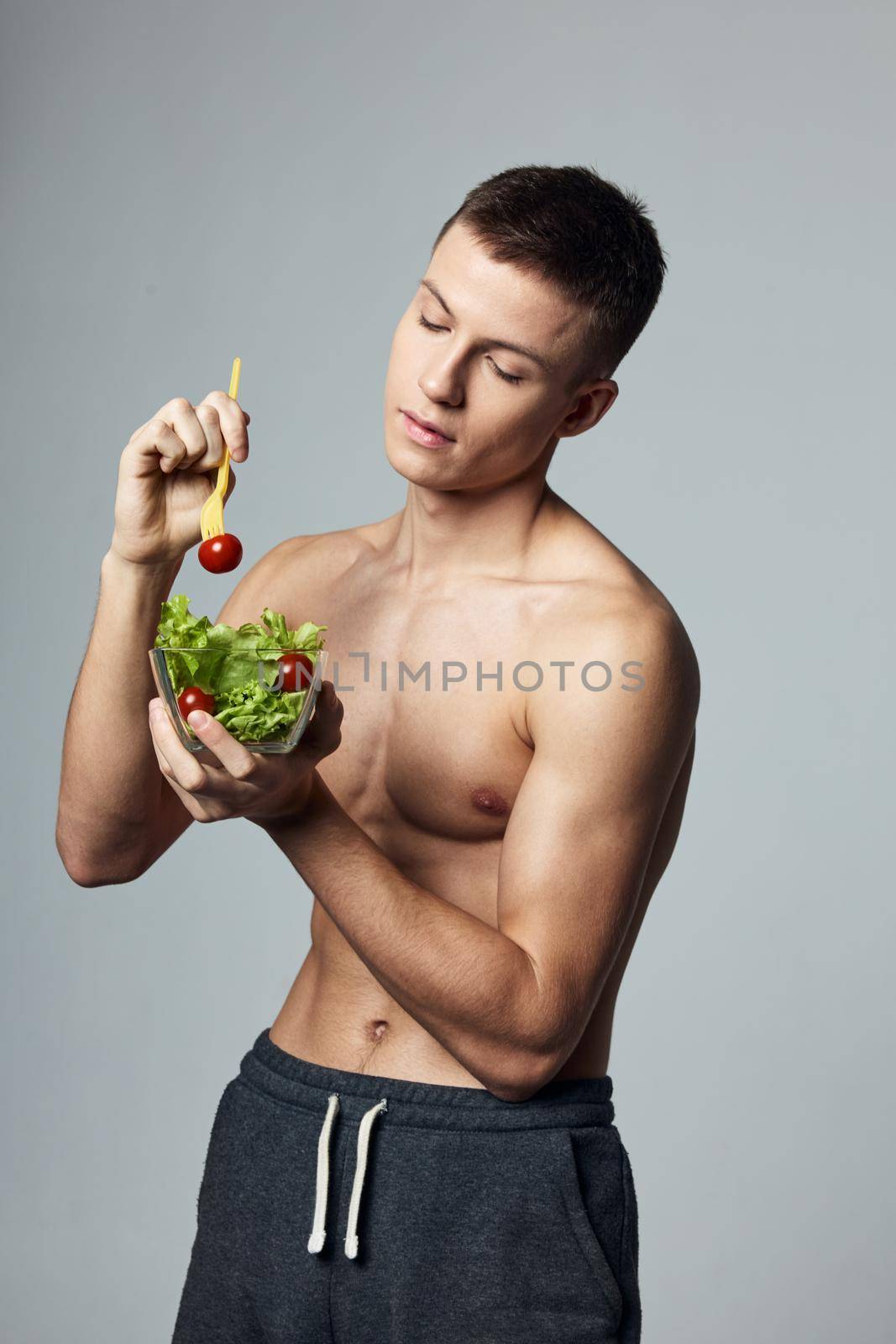 athletic man with a pumped body plate salad vegetables healthy food lifestyle. High quality photo