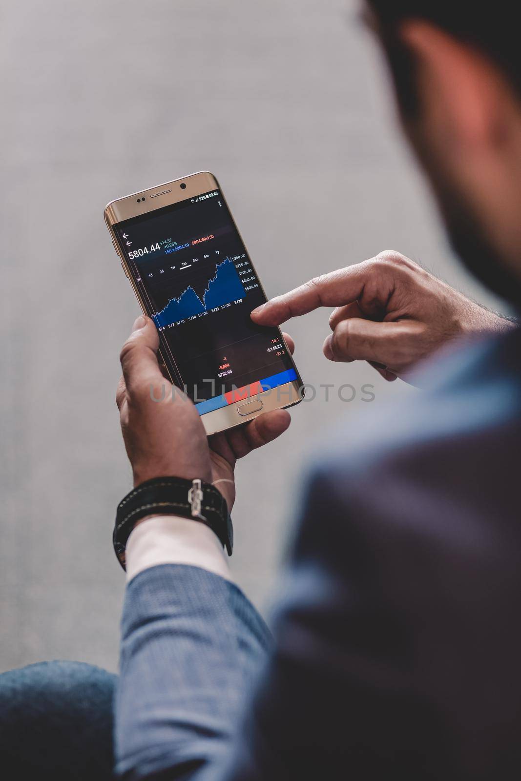 Close up of a businessman using smart phone. Focus on mobile device.