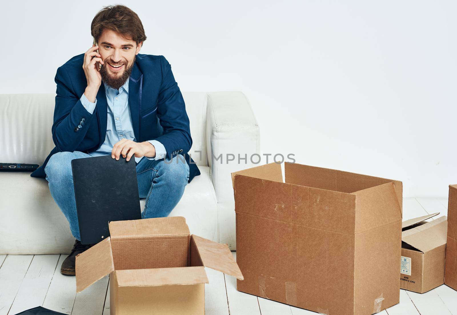 business man sitting on the couch talking on the phone box official. High quality photo