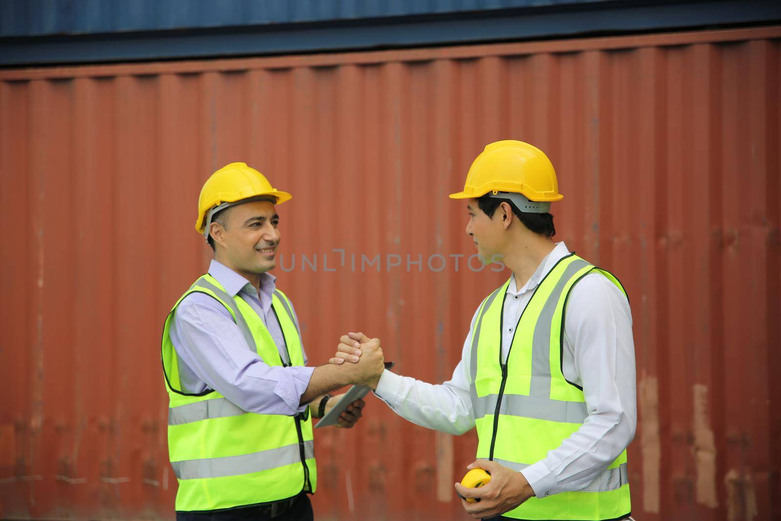 Logistics engineer control at the port, loading containers for trucks export and importing logistic concept