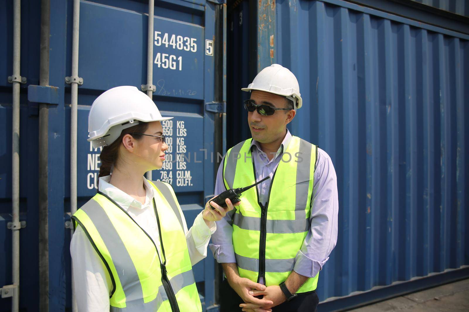 Logistics engineer control at the port, loading containers for trucks export and importing logistic concept