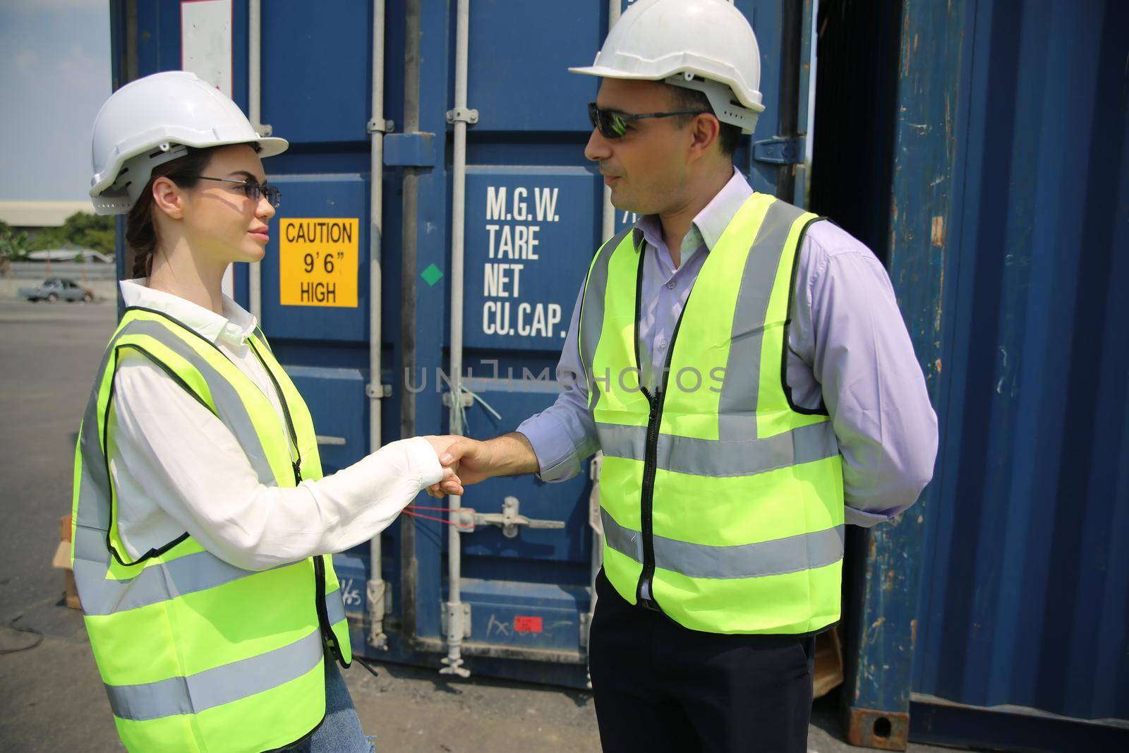 Logistics engineer control at the port, loading containers for trucks export and importing logistic concept