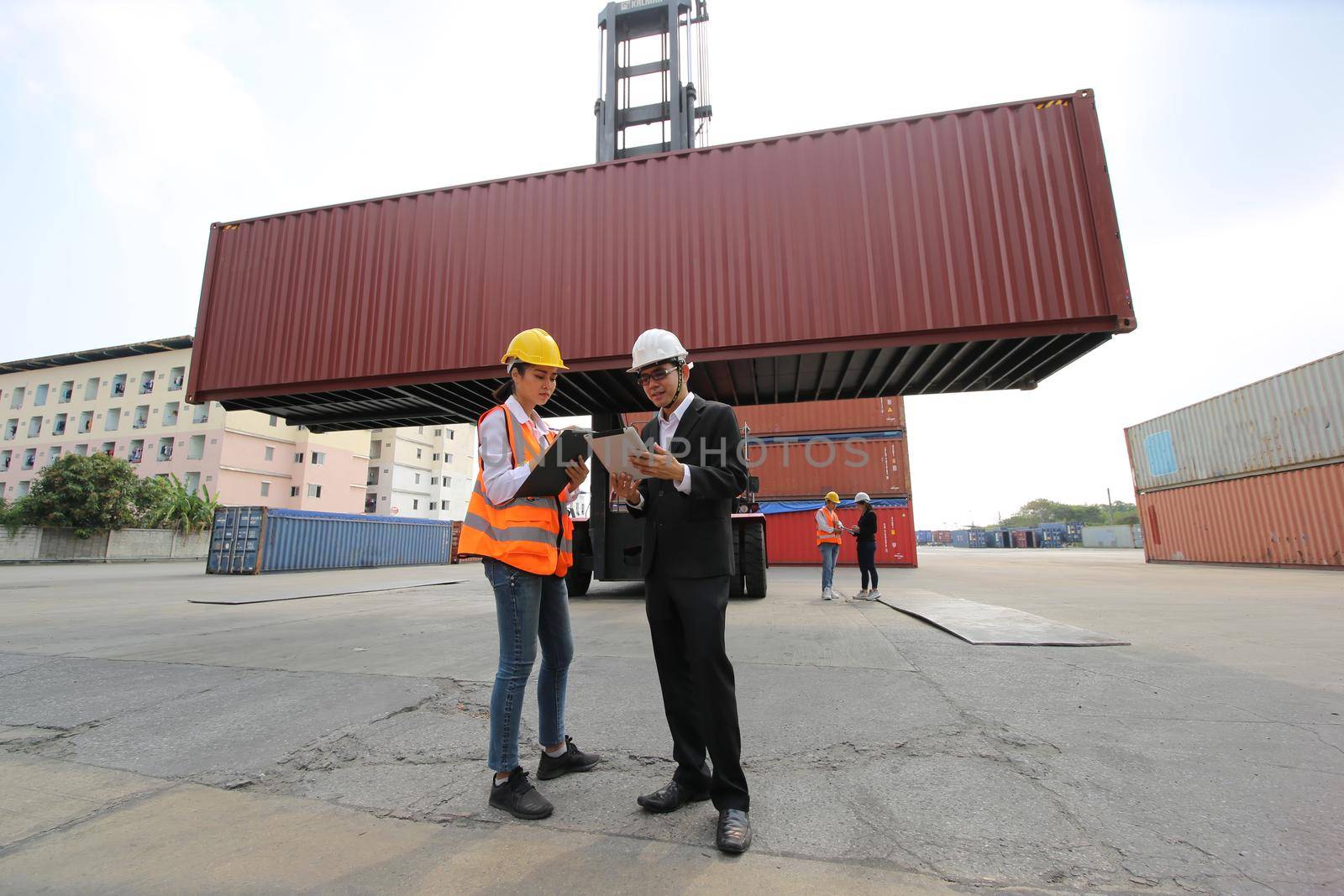 Foreman control loading Containers box from Cargo freight ship for import export. Container Warehouse Worker