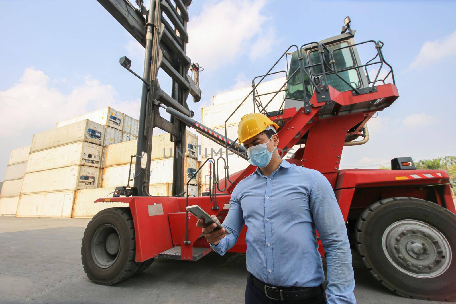 Engineer or supervisor checking and control loading Containers box from Cargo at harbor.Foreman control Industrial Container Cargo freight ship at industry.Transportation and logistic concept. 