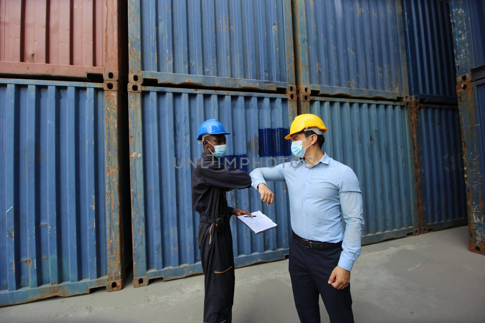 Engineer or supervisor checking and control loading Containers box from Cargo at harbor.Foreman control Industrial Container Cargo freight ship at industry.Transportation and logistic concept. 