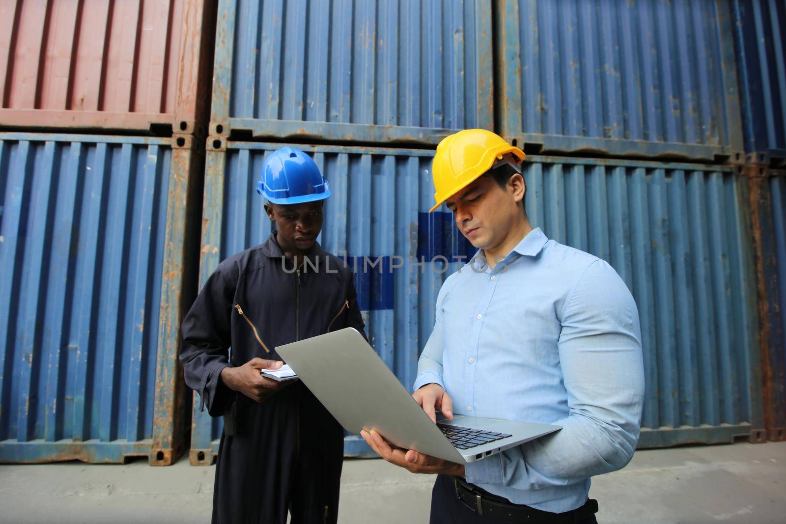 Engineer or supervisor checking and control loading Containers box from Cargo at harbor.Foreman control Industrial Container Cargo freight ship at industry.Transportation and logistic concept. 