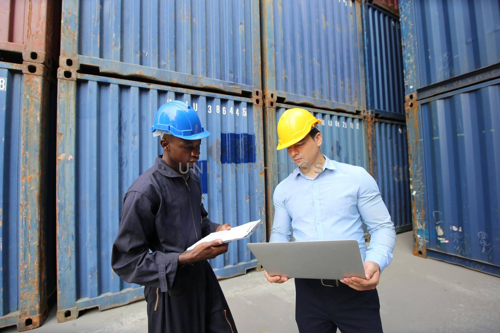 Engineer or supervisor checking and control loading Containers box from Cargo at harbor.Foreman control Industrial Container Cargo freight ship at industry.Transportation and logistic concept. 