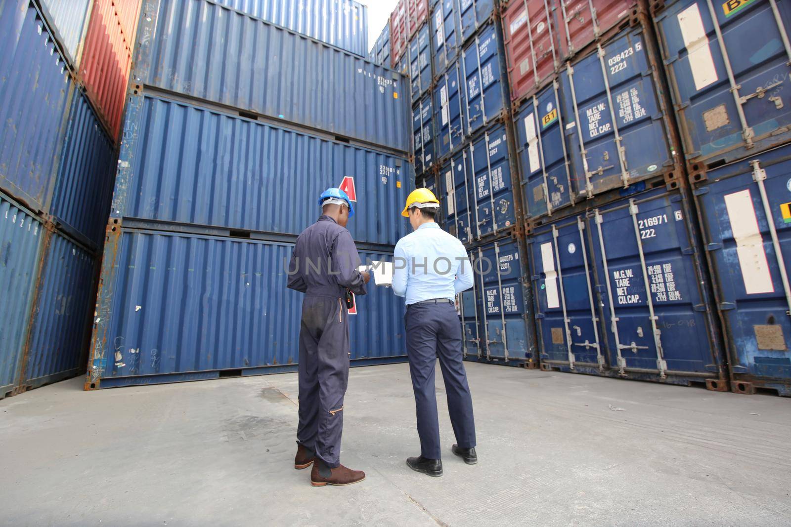 Engineer or supervisor checking and control loading Containers box from Cargo at harbor.Foreman control Industrial Container Cargo freight ship at industry.Transportation and logistic concept.  by chuanchai