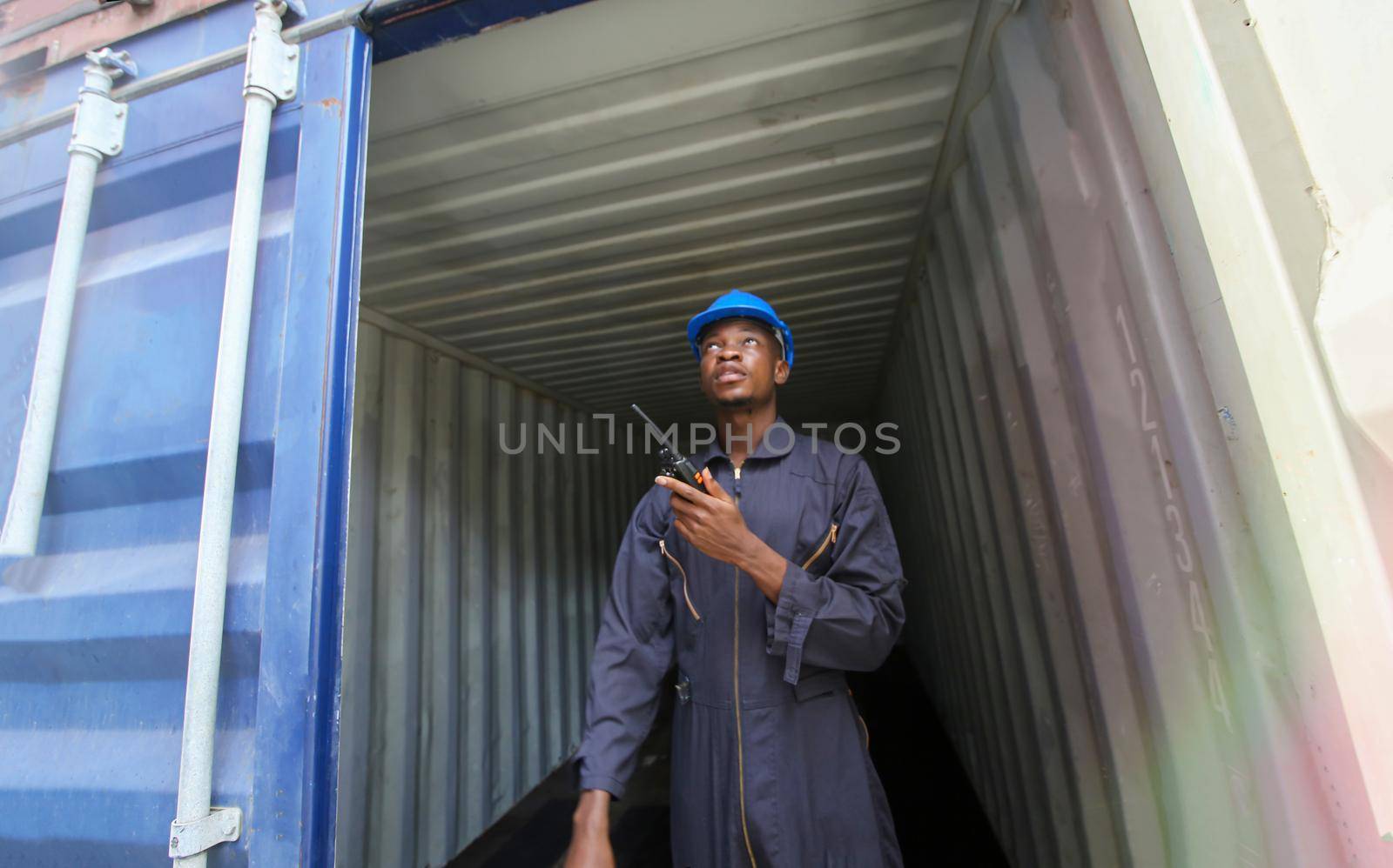 Engineer or supervisor checking and control loading Containers box from Cargo at harbor.Foreman control Industrial Container Cargo freight ship at industry.Transportation and logistic concept. 