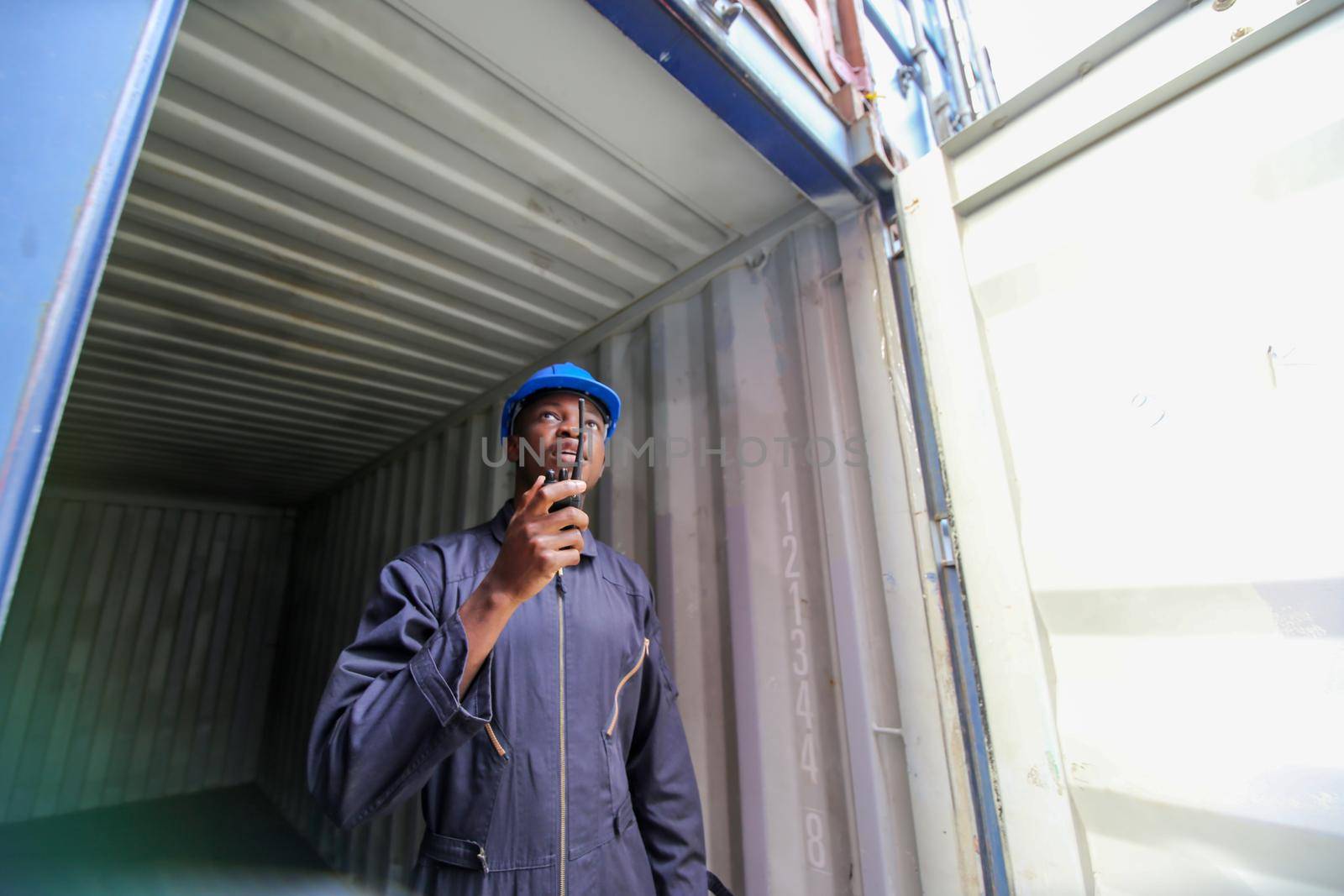 Engineer or supervisor checking and control loading Containers box from Cargo at harbor.Foreman control Industrial Container Cargo freight ship at industry.Transportation and logistic concept. 