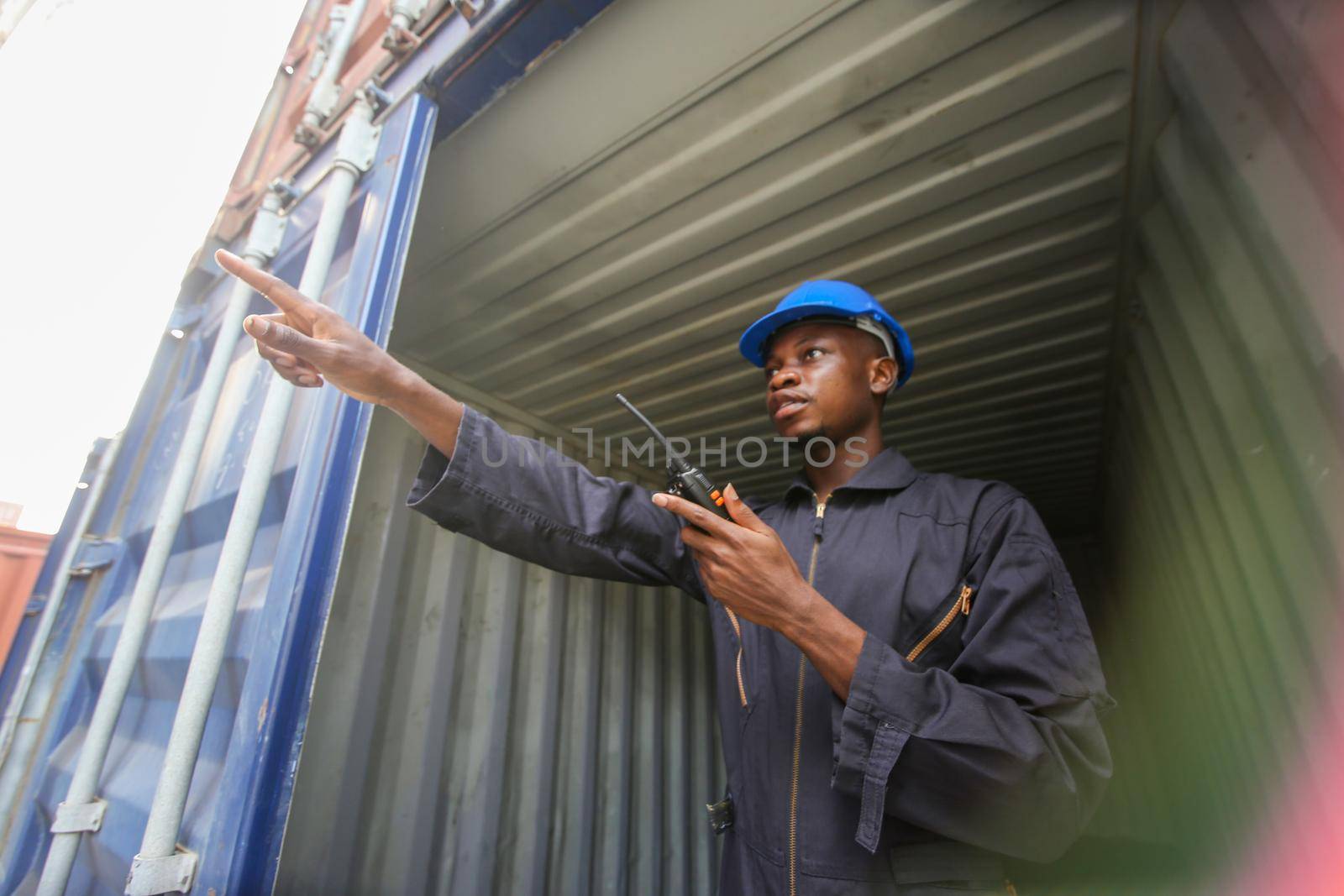 Engineer or supervisor checking and control loading Containers box from Cargo at harbor.Foreman control Industrial Container Cargo freight ship at industry.Transportation and logistic concept. 