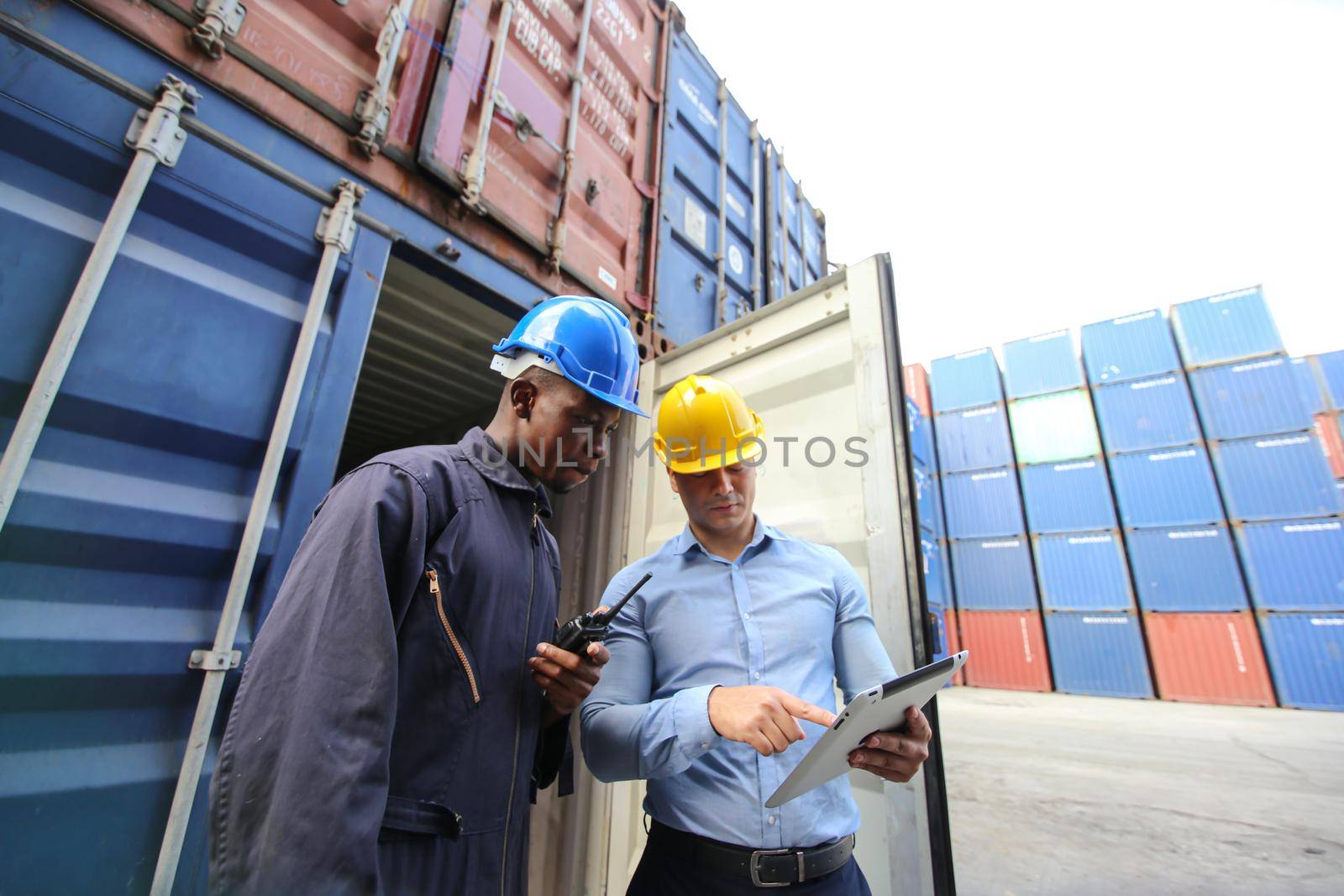 Engineer or supervisor checking and control loading Containers box from Cargo at harbor.Foreman control Industrial Container Cargo freight ship at industry.Transportation and logistic concept.  by chuanchai