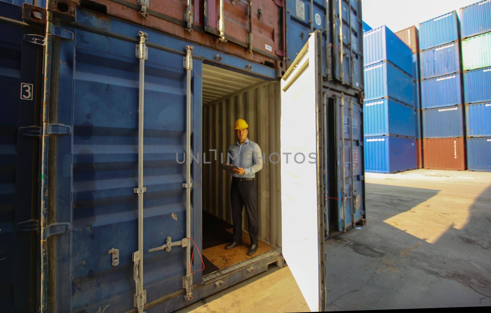 Engineer or supervisor checking and control loading Containers box from Cargo at harbor.Foreman control Industrial Container Cargo freight ship at industry.Transportation and logistic concept. 