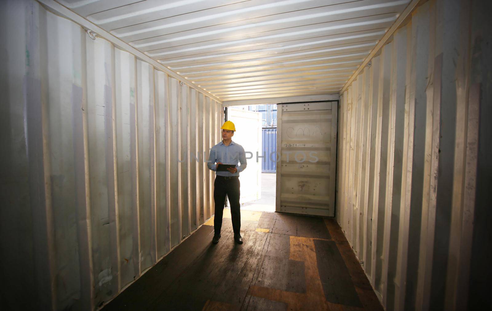 Engineer or supervisor checking and control loading Containers box from Cargo at harbor.Foreman control Industrial Container Cargo freight ship at industry.Transportation and logistic concept. 