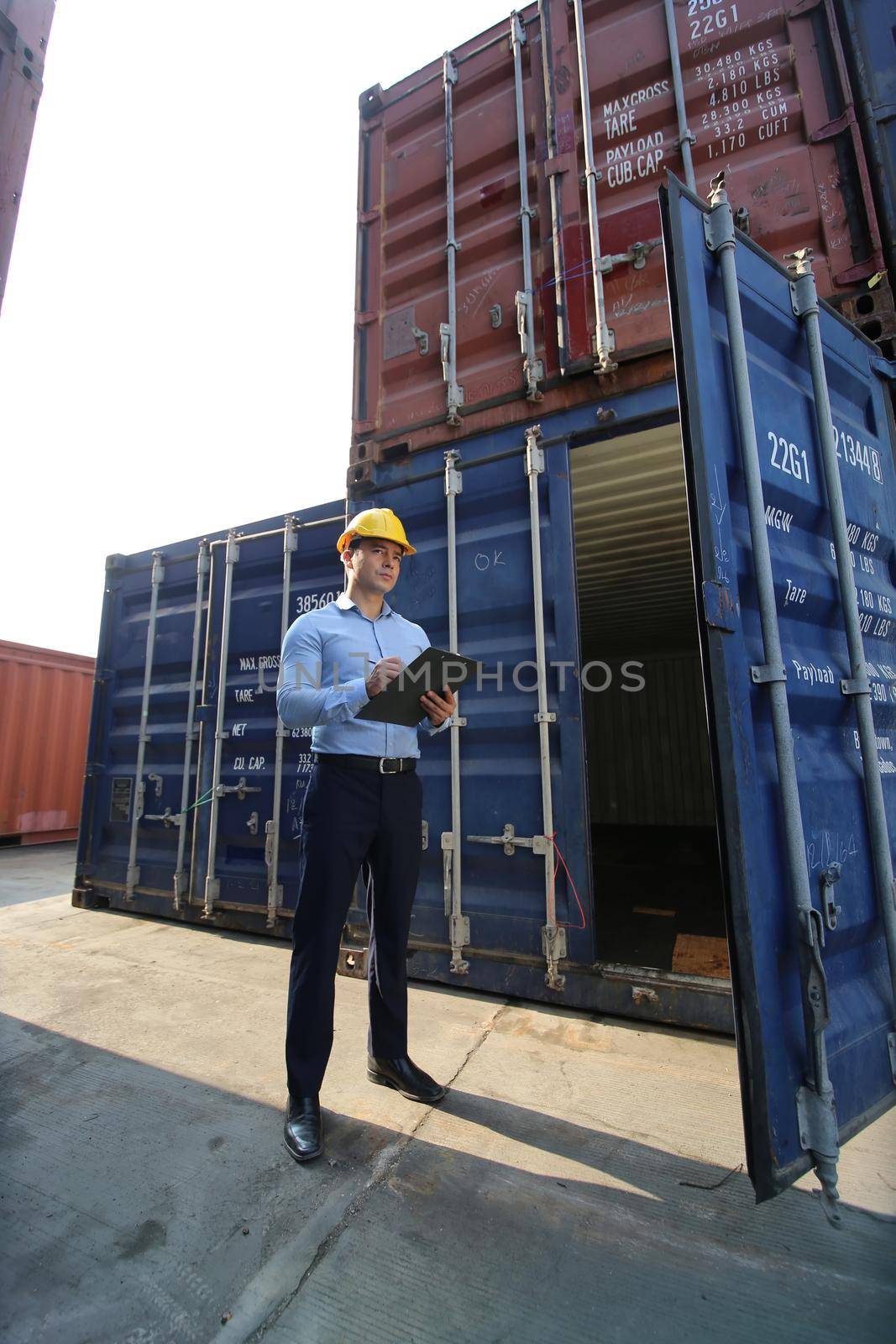 Engineer or supervisor checking and control loading Containers box from Cargo at harbor.Foreman control Industrial Container Cargo freight ship at industry.Transportation and logistic concept.  by chuanchai