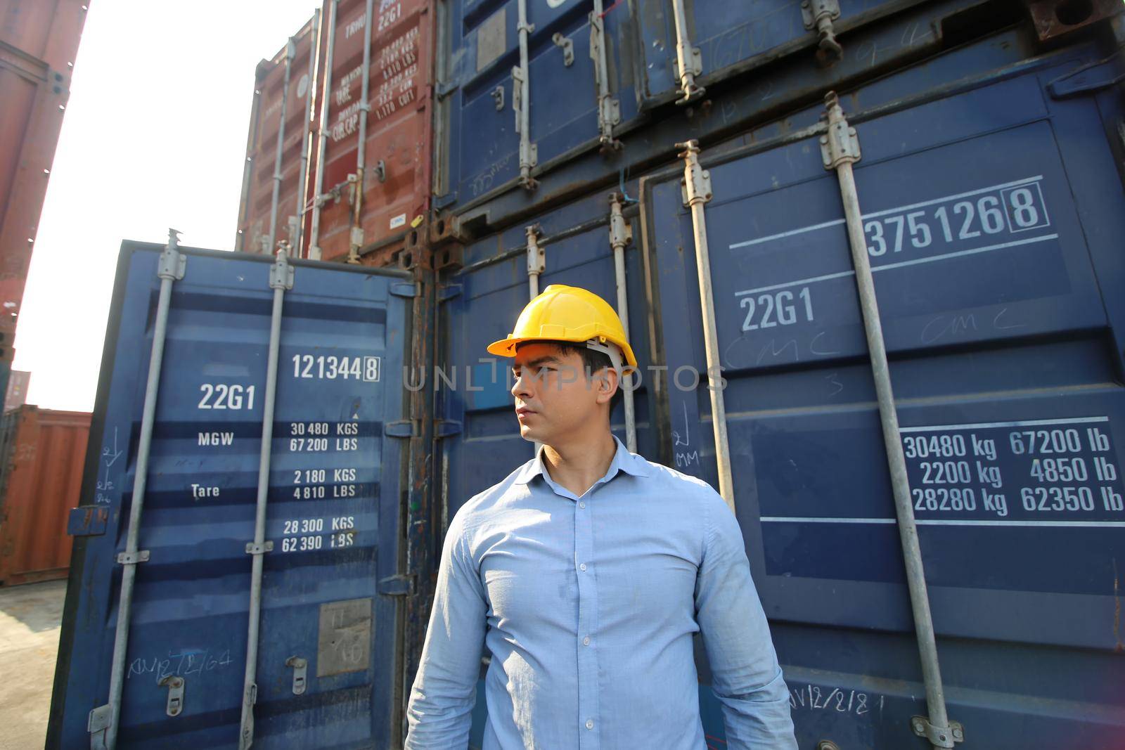 Engineer or supervisor checking and control loading Containers box from Cargo at harbor.Foreman control Industrial Container Cargo freight ship at industry.Transportation and logistic concept. 