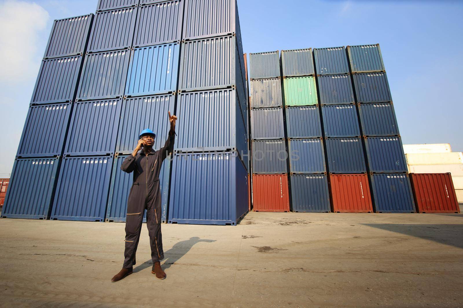 Engineer or supervisor checking and control loading Containers box from Cargo at harbor.Foreman control Industrial Container Cargo freight ship at industry.Transportation and logistic concept. 