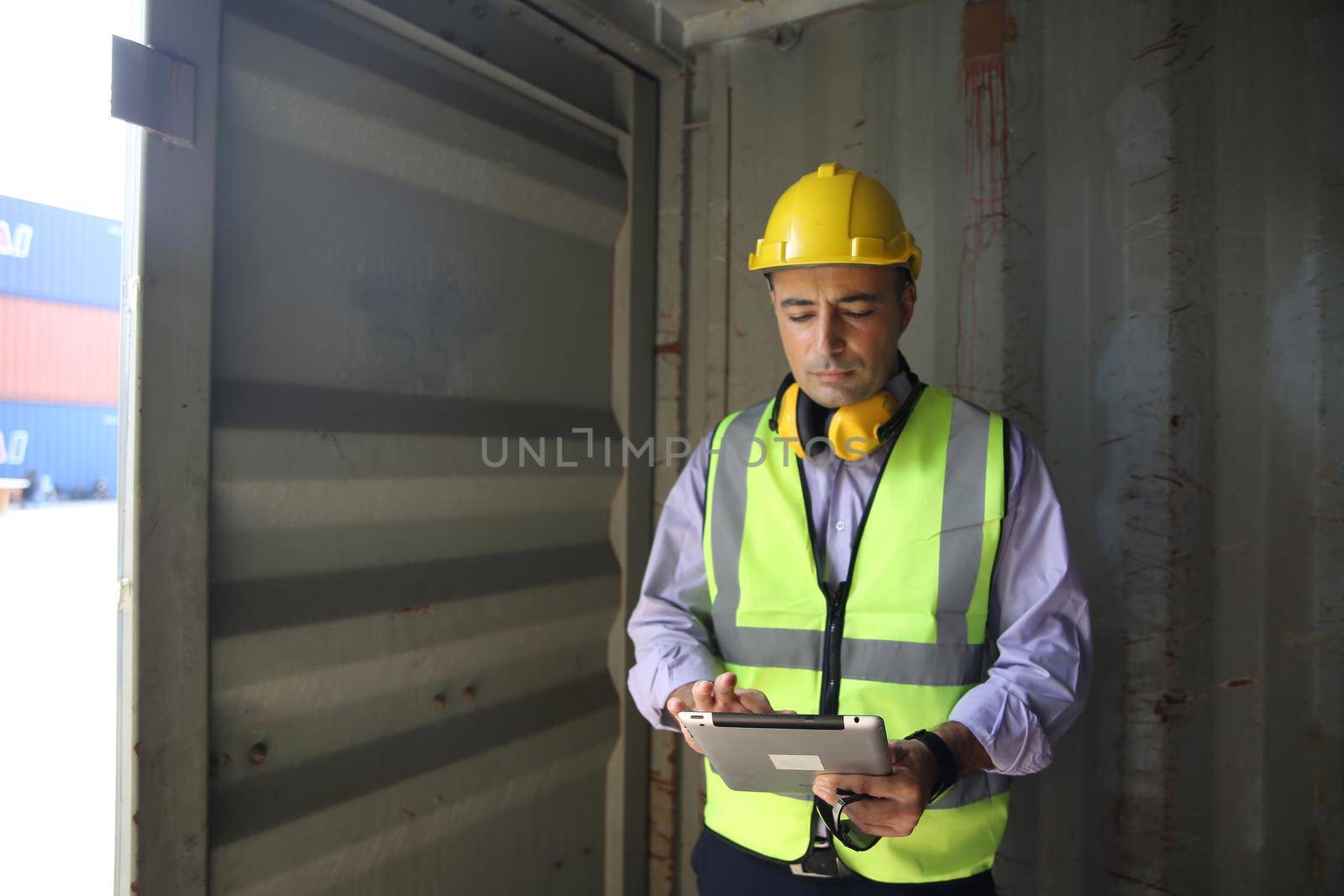 Foreman control loading Containers box from Cargo freight ship for import export.