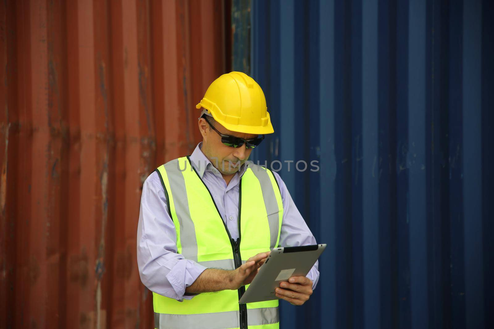 Foreman control loading Containers box from Cargo freight ship for import export.