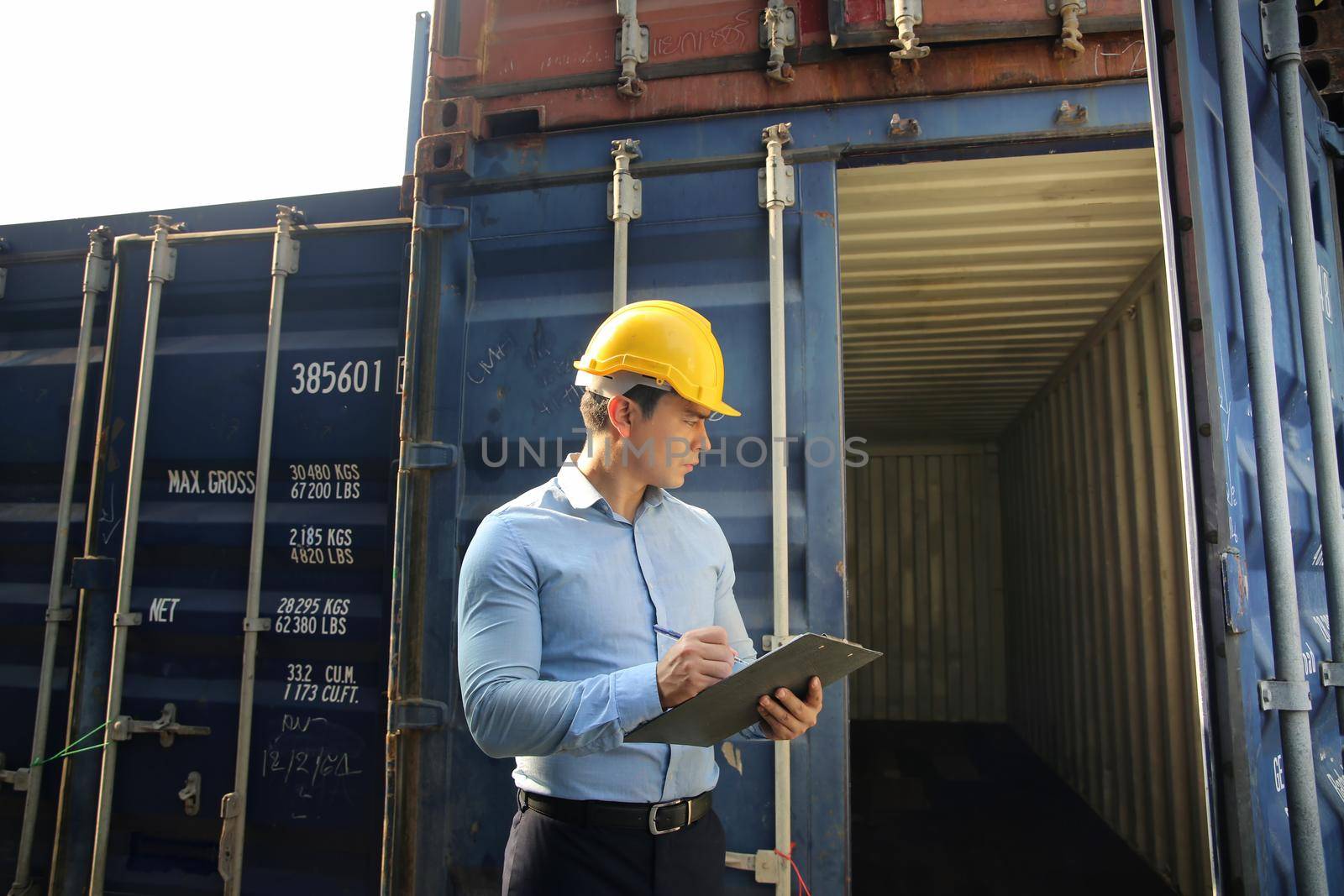 Foreman control loading Containers box from Cargo freight ship for import export.