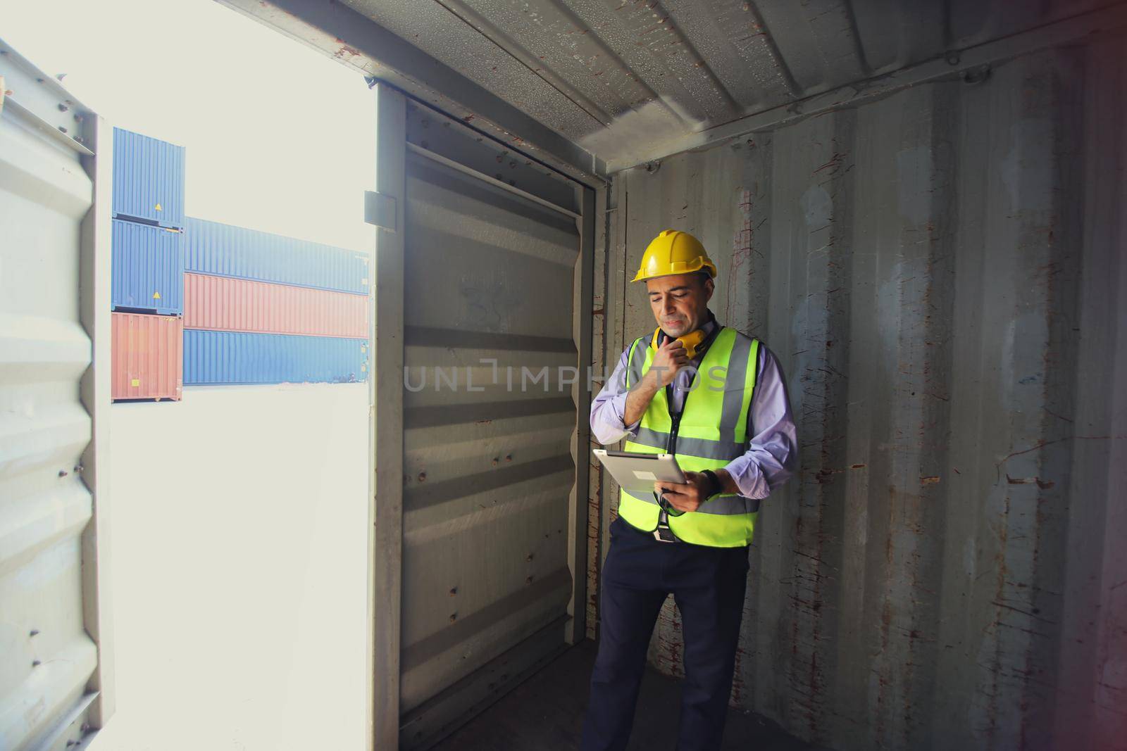 Foreman control loading Containers box from Cargo freight ship for import export.