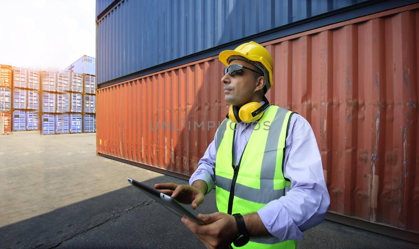Foreman control loading Containers box from Cargo freight ship for import export.