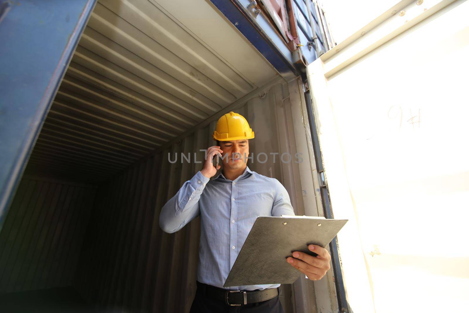 Foreman control loading Containers box from Cargo freight ship for import export.