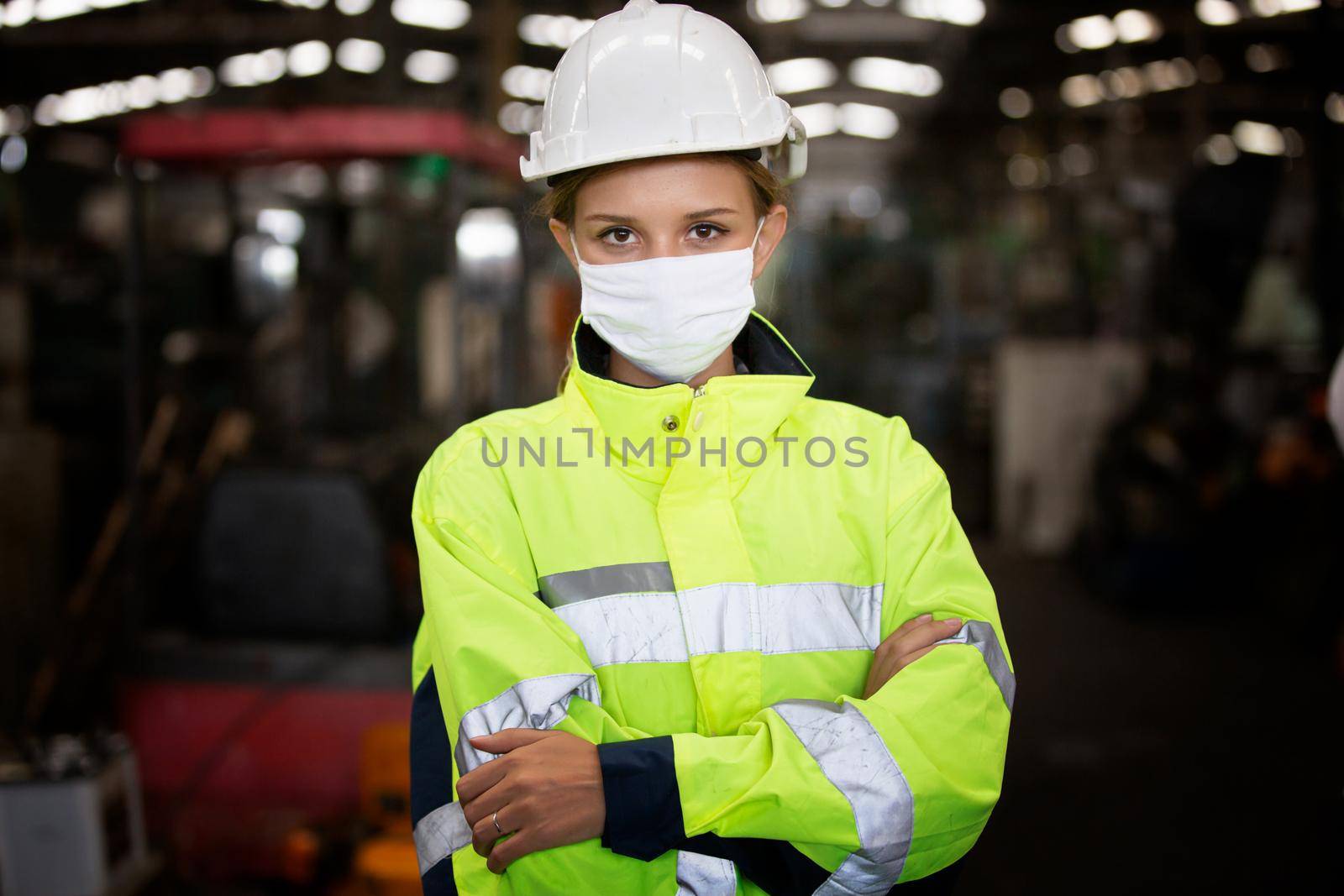 Workers wear protective face masks for safety in machine industrial factory., Woman worker wearing safety goggles control lathe machine to drill components. Metal lathe industrial manufacturing factory