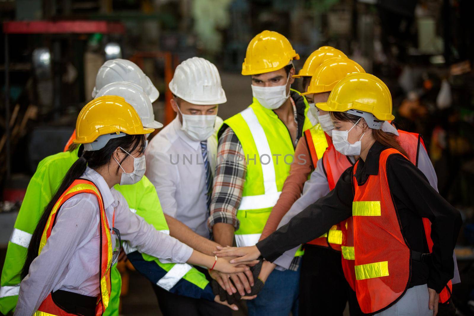 group of workers, change of workers in the factory, people go in helmets and uniforms for an industrial enterprise, Workers wear protective face masks for safety in machine industrial factory.