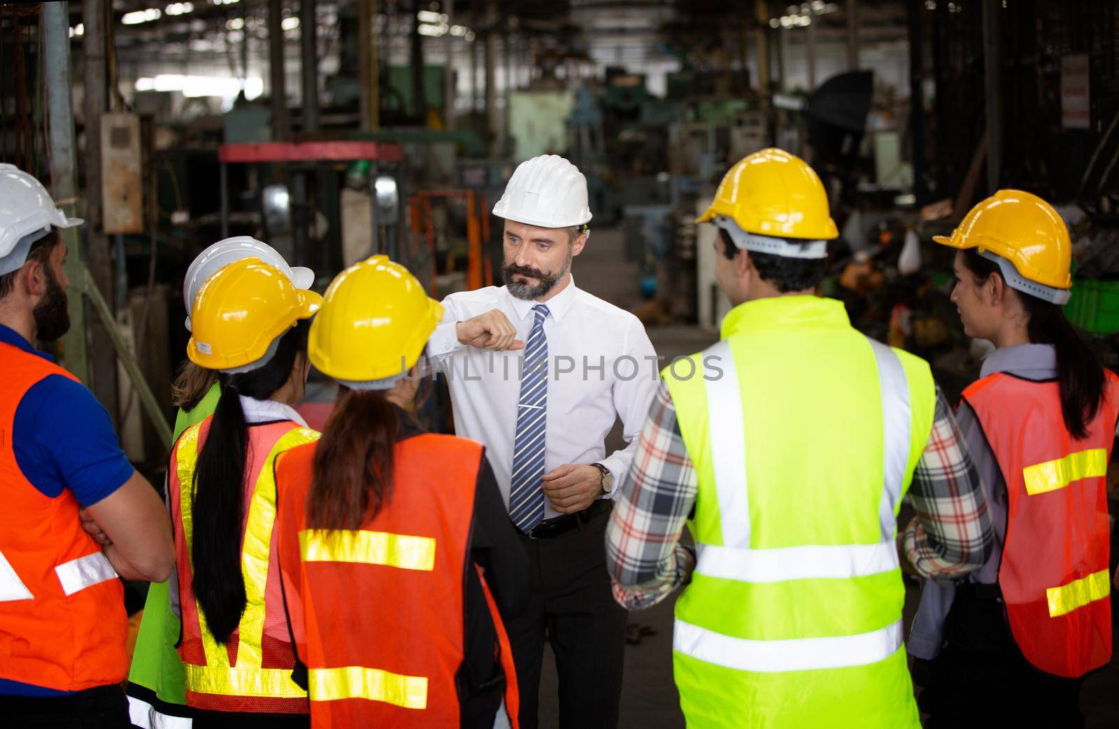 group of workers, change of workers in the factory, people go in helmets and uniforms for an industrial enterprise