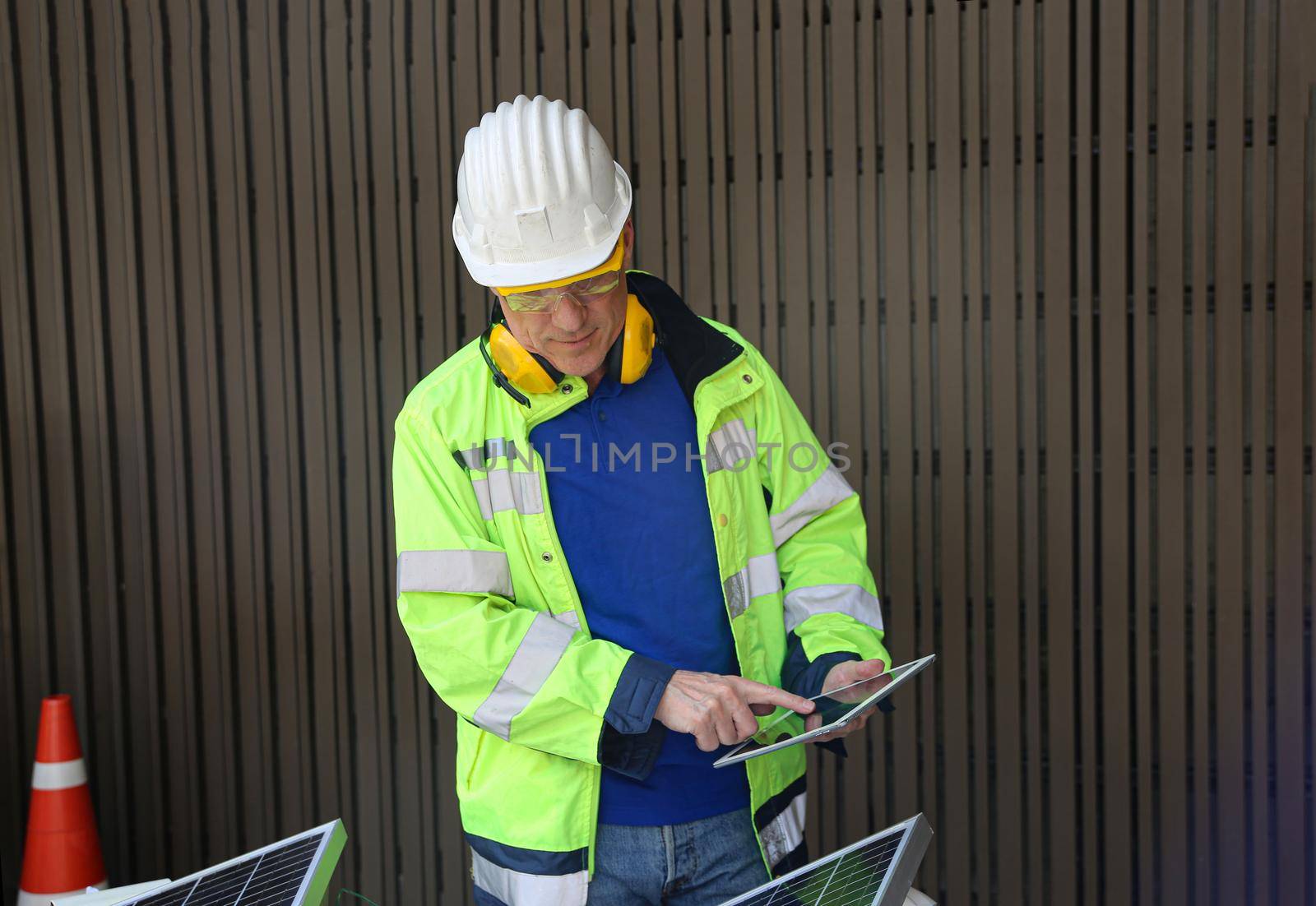 maintenance engineer, Solar energy systems engineer perform analysis solar panels, Portrait of engineer man or worker, people, with solar panels or solar cells on the roof in farm. Power plant with green field, renewable energy source in American. Eco technology for electric power.