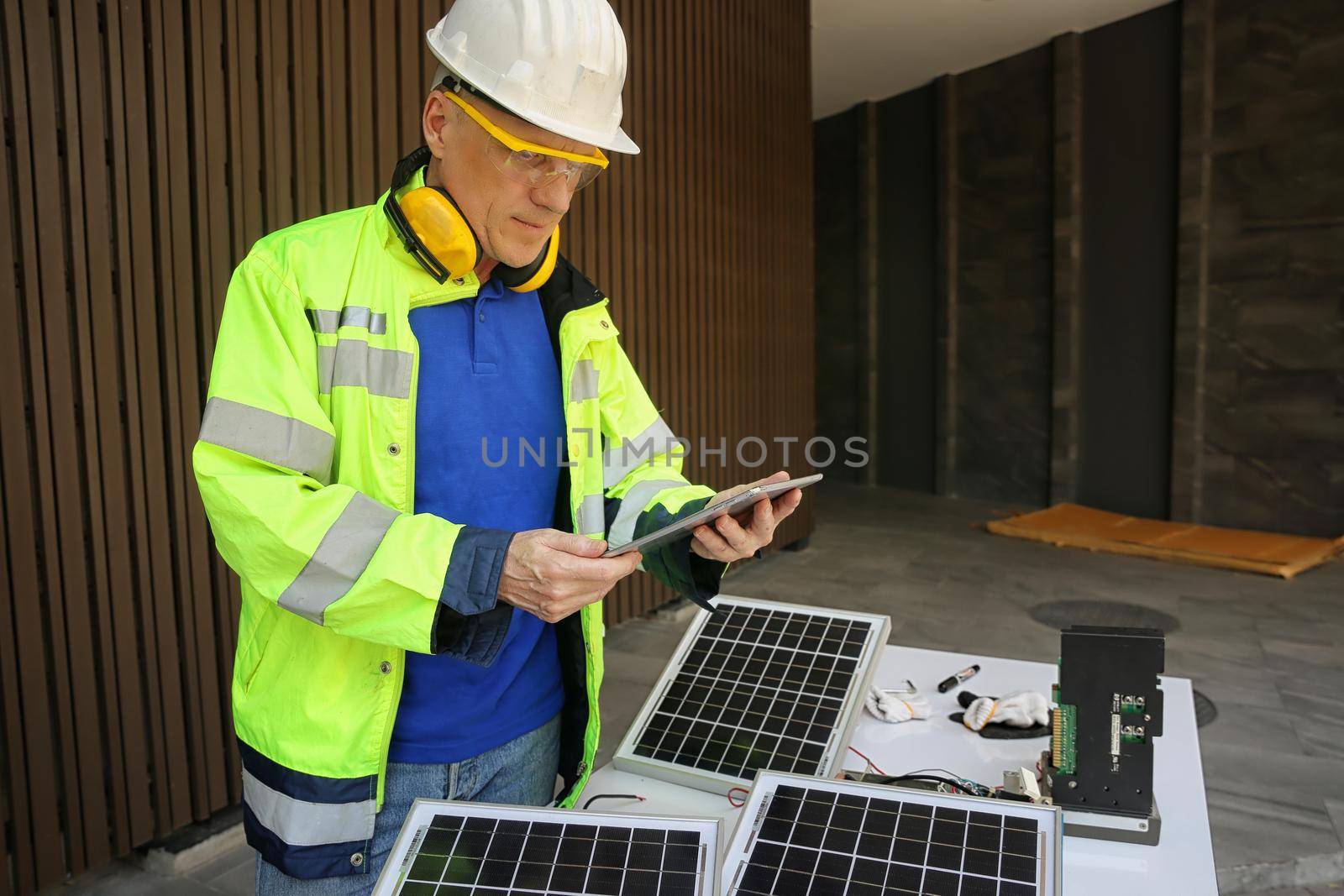 maintenance engineer, Solar energy systems engineer perform analysis solar panels, Portrait of engineer man or worker, people, with solar panels or solar cells on the roof in farm. Power plant with green field, renewable energy source in American. Eco technology for electric power.