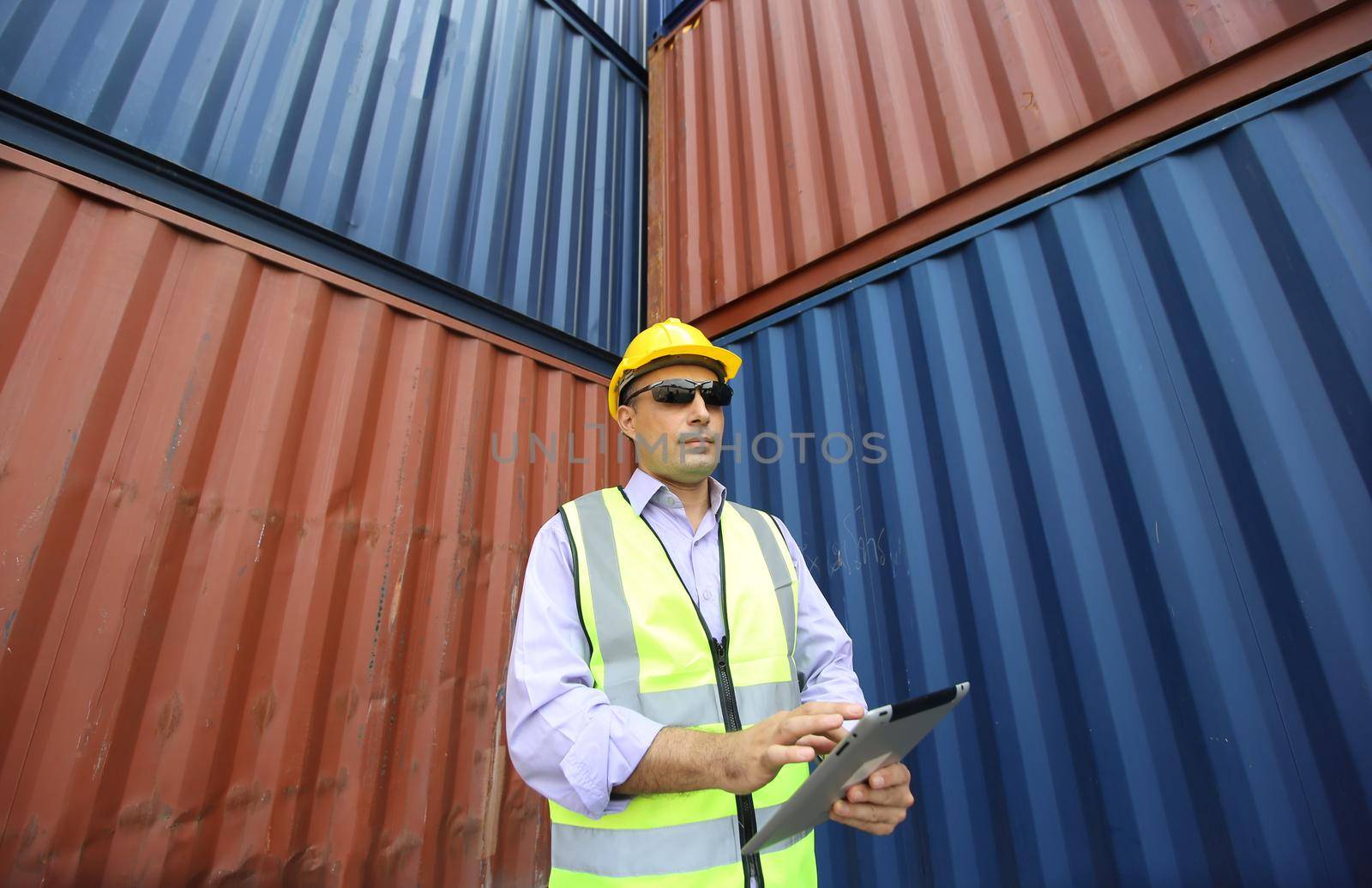  supervisor checking and control loading Containers box from Cargo at harbor. Foreman control Industrial Container Cargo freight ship at industry. Transportation and logistic concept.