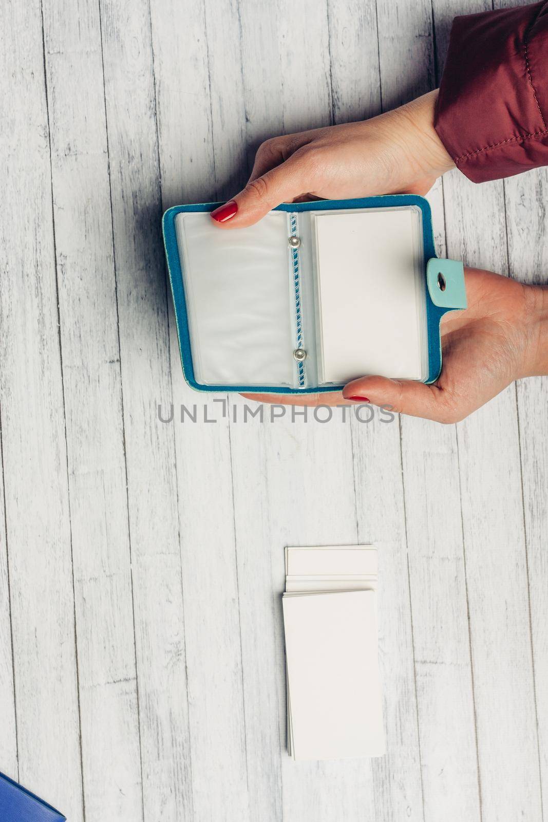 open card holder in female hands on a wooden background top view. High quality photo
