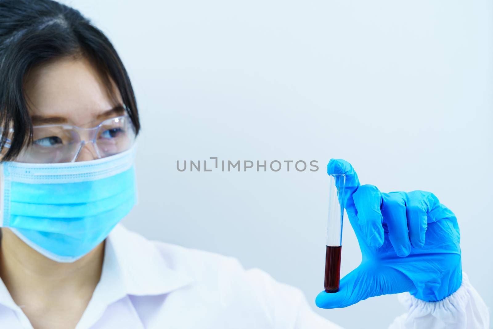 Technician scientist analyzing holding blood sample in test tube in laboratory for testing it on COVID, COVID-19, coronavirus virus analysis