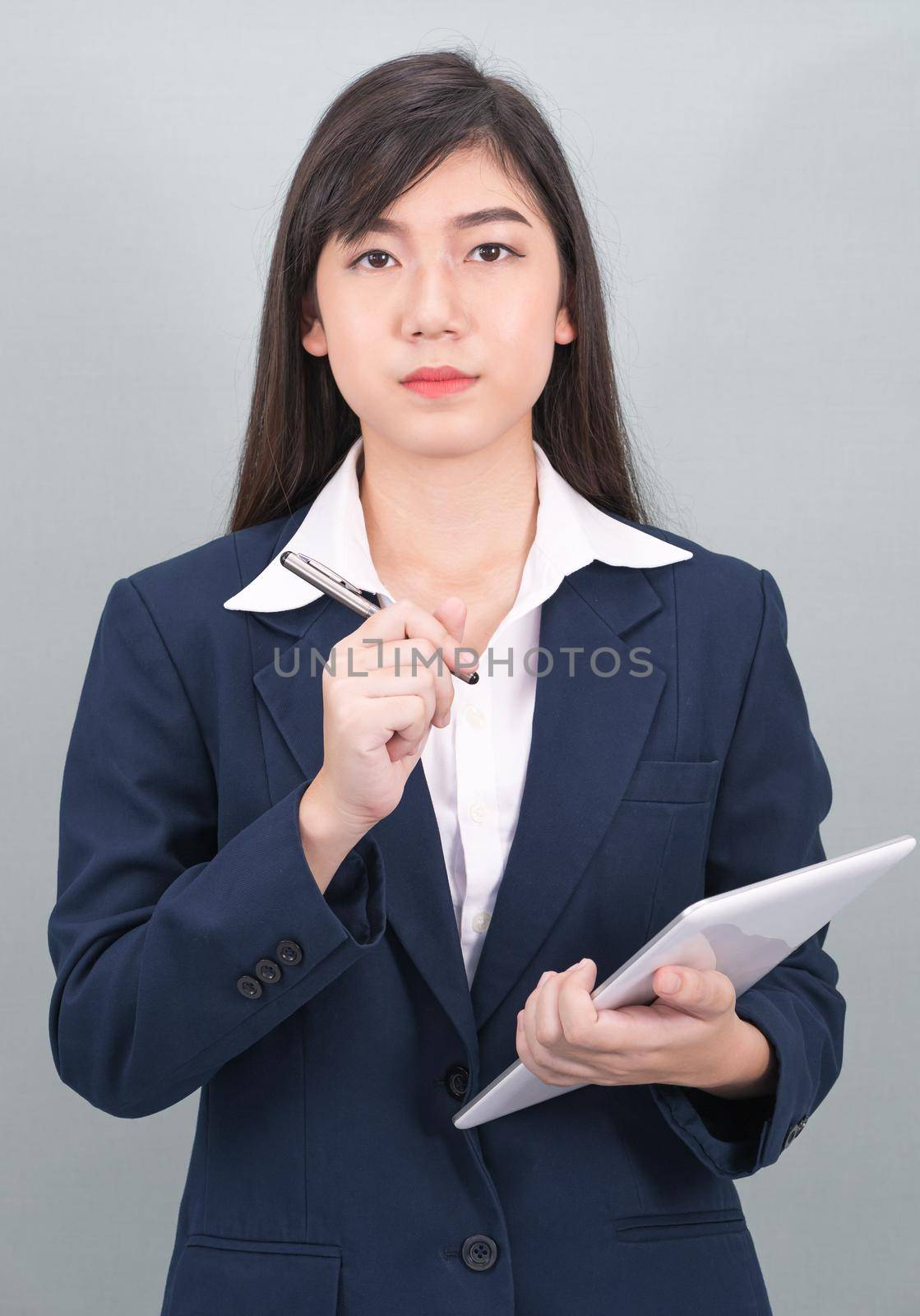 Woman in suit using computer digital tablet on gray by stoonn