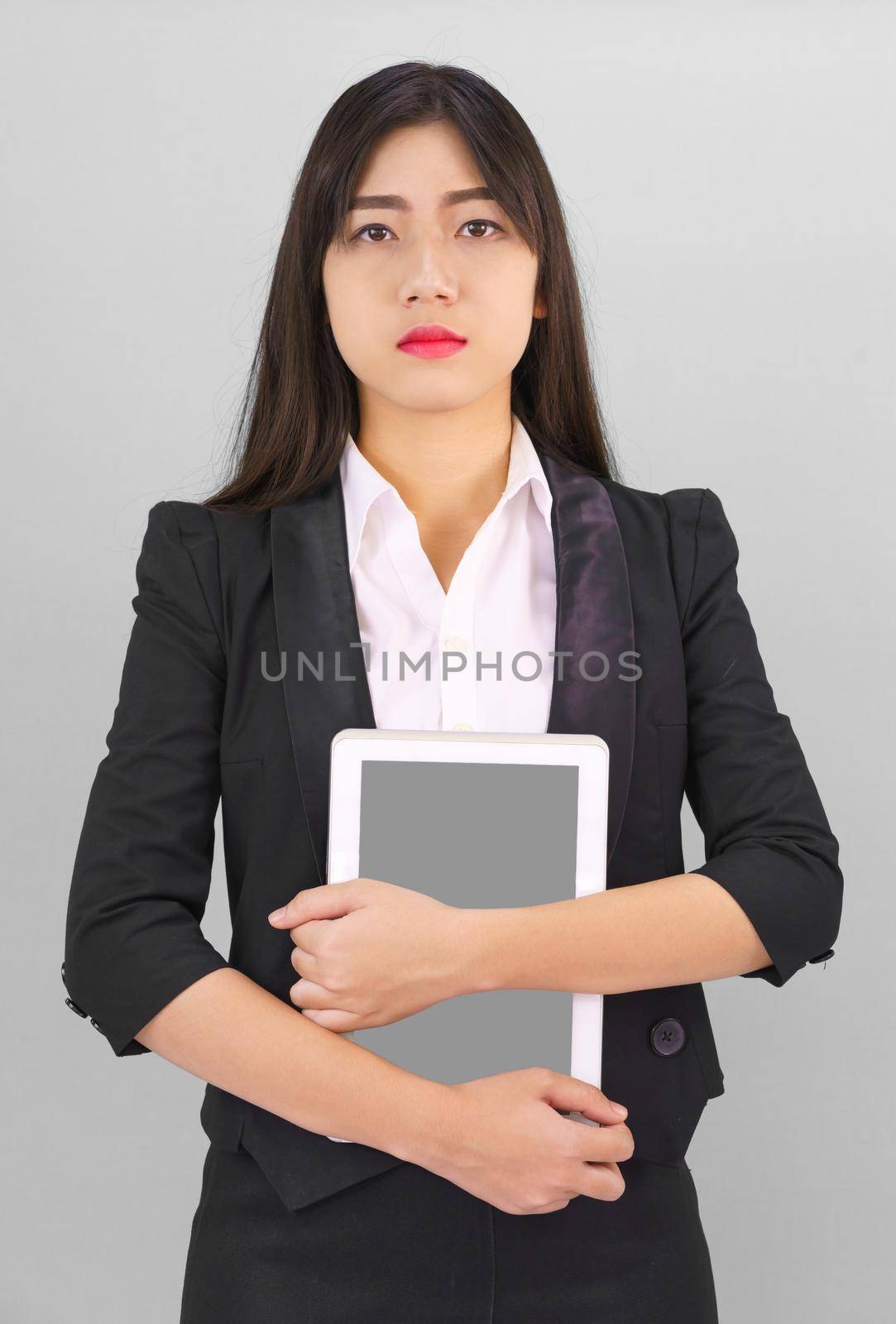 Young women standing in suit holding digital tablet by stoonn