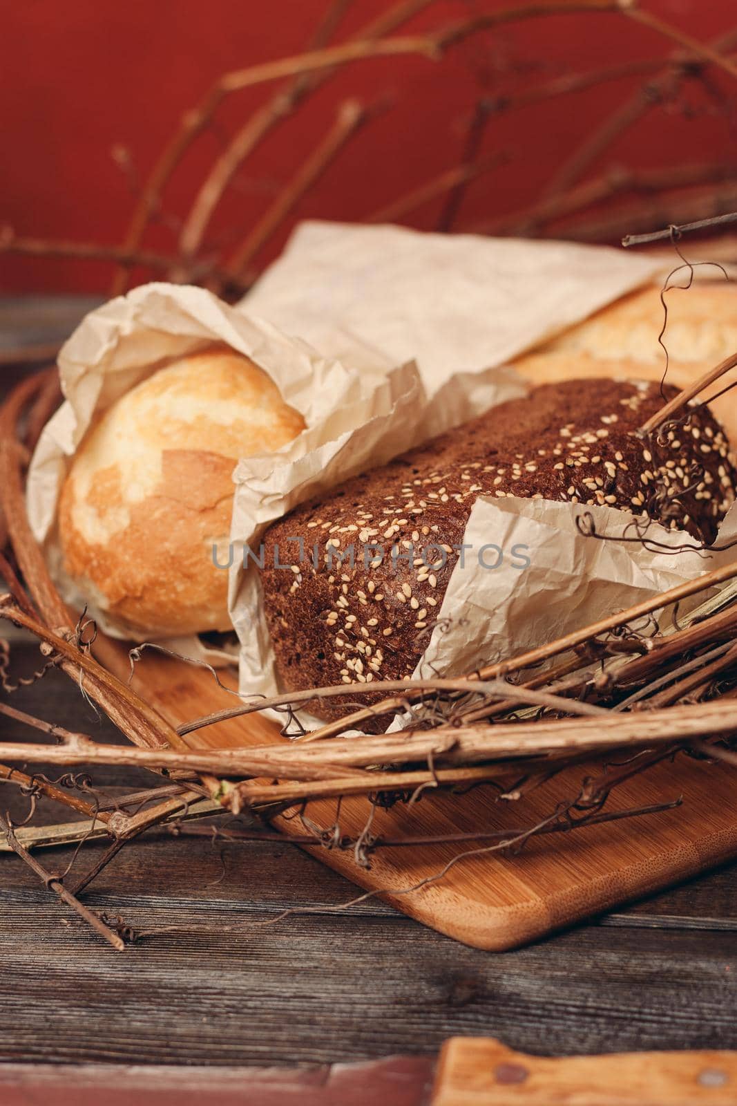 a loaf of fresh bread flour product in a bird's nest on a wooden table on a red background. High quality photo